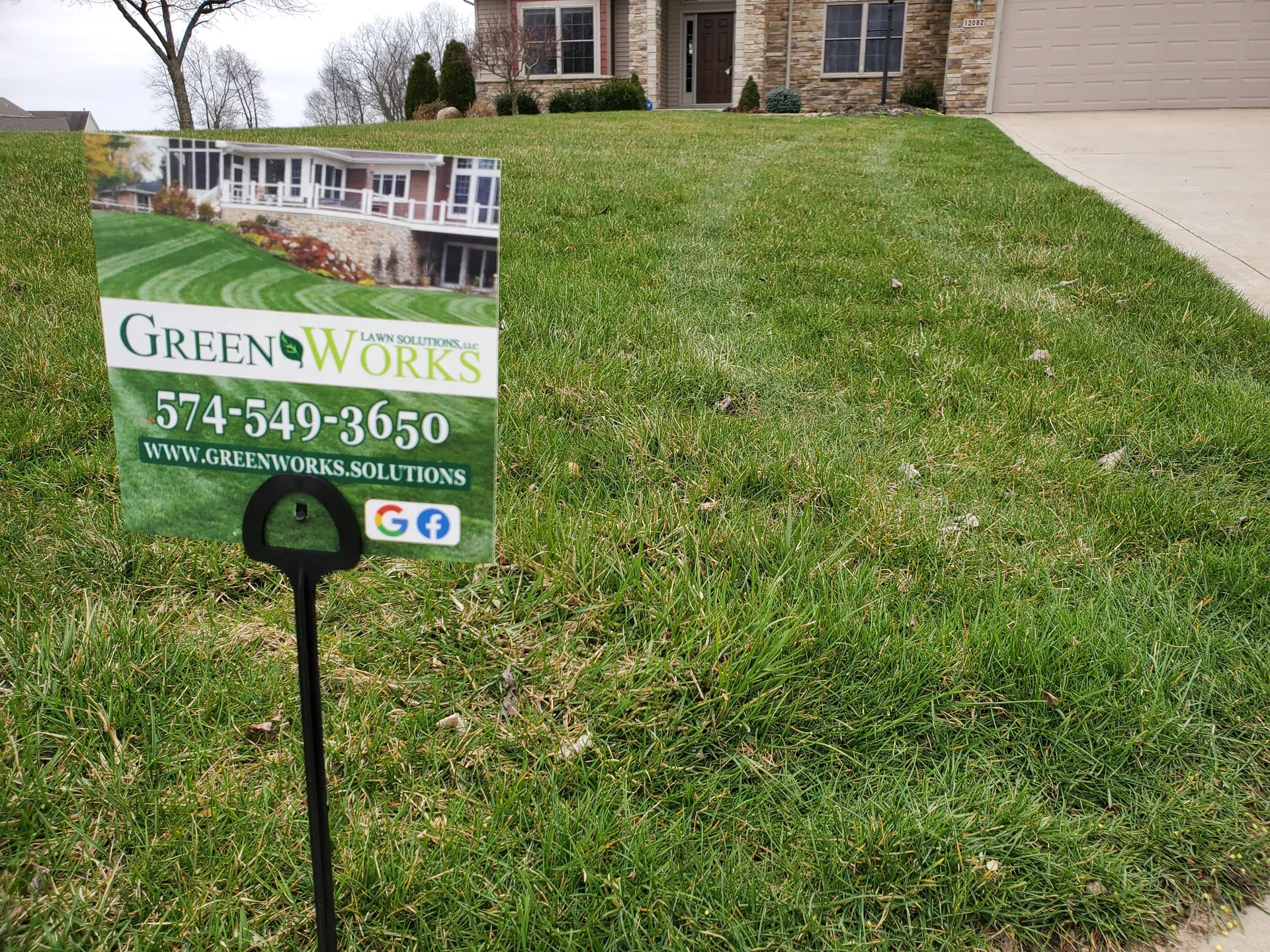 A GreenWorks yard sign staked in a treated front lawn in a Kosciusko County neighborhood